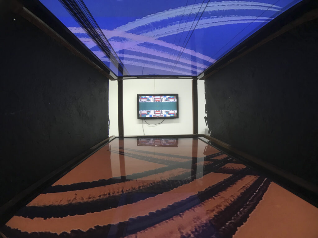 Two opposing TV damaged screens showing videos. Art installation
