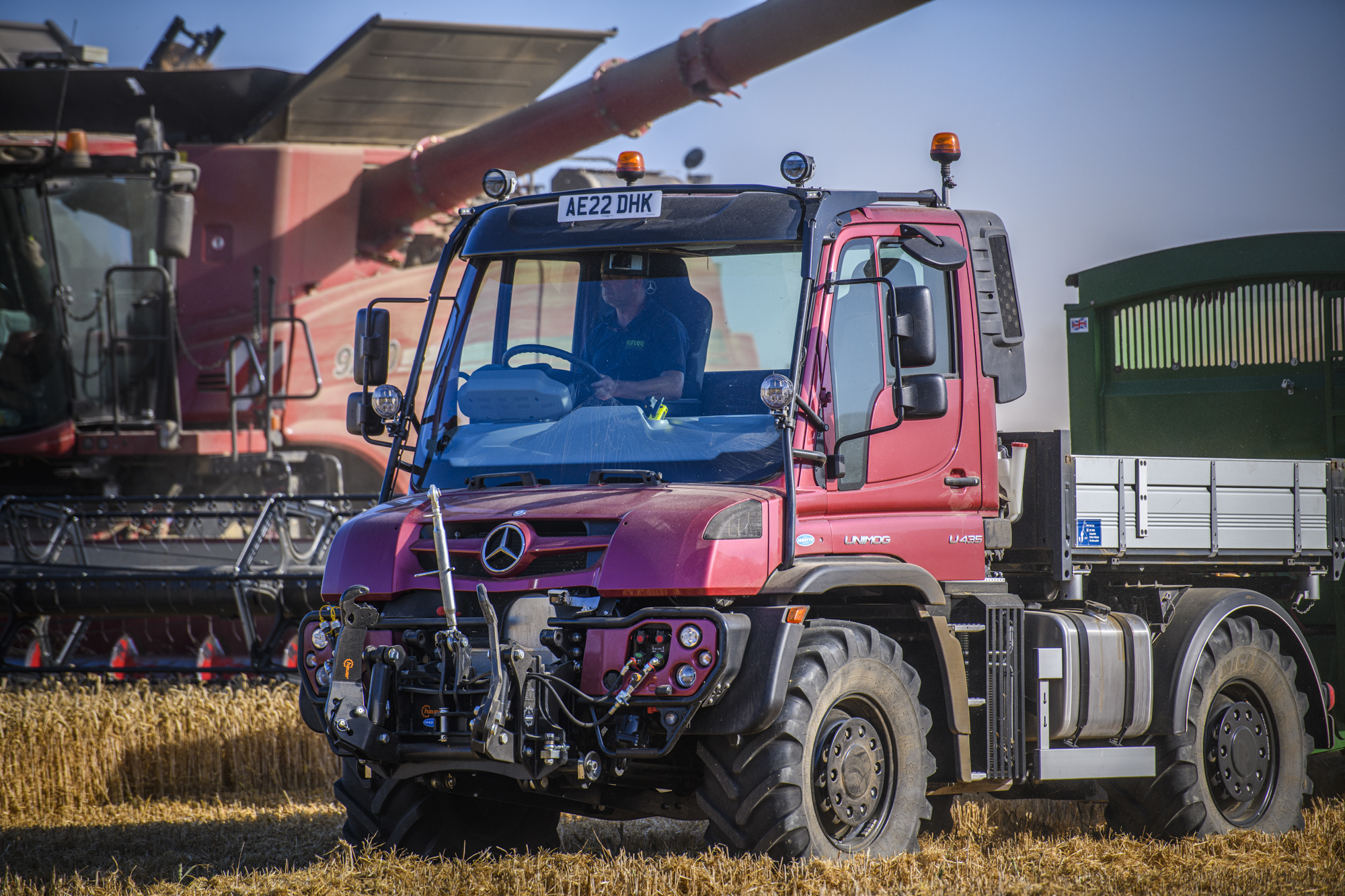 Unimog U435 alongside combine