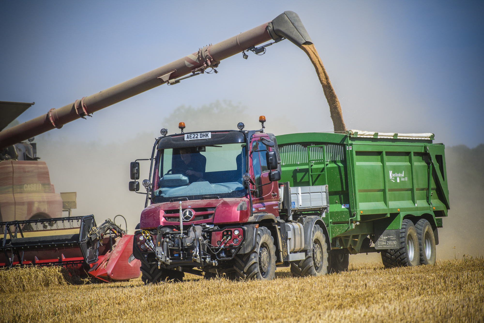 Unimog U435 alongside combine